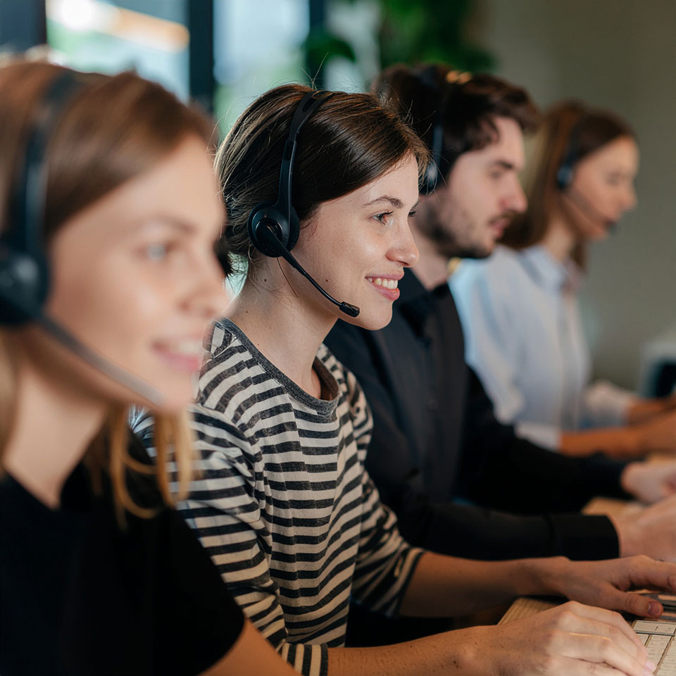 Team mit Headsets in modernem Büro – Sinnbild für Direct Search und persönliche Kommunikation im Recruiting.