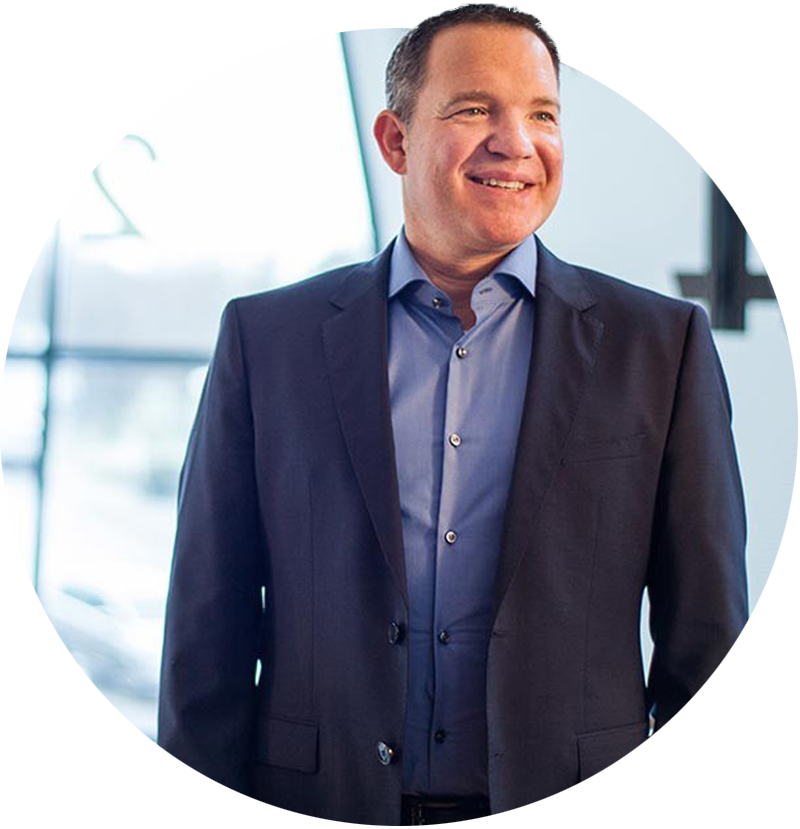 Geschäftsführer in Businesskleidung lächelt in modernem Headquarter – Symbol für Leadership, Vertrauen und strategische Kompetenz im HR Marketing und Recruiting.