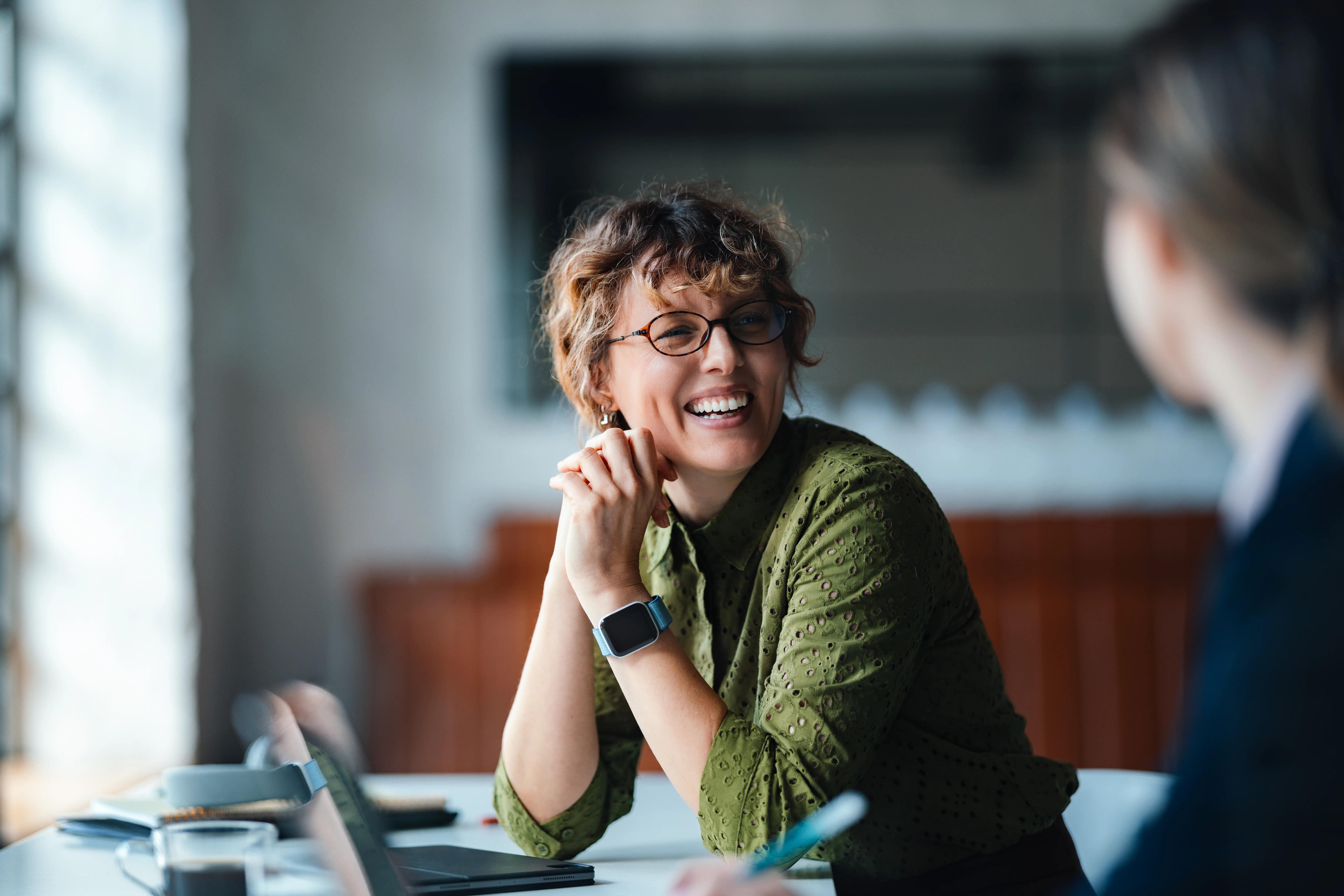 Frau lacht in die Kamera. Symbolbild für die Freude an der Arbeit bei der Power People Group.