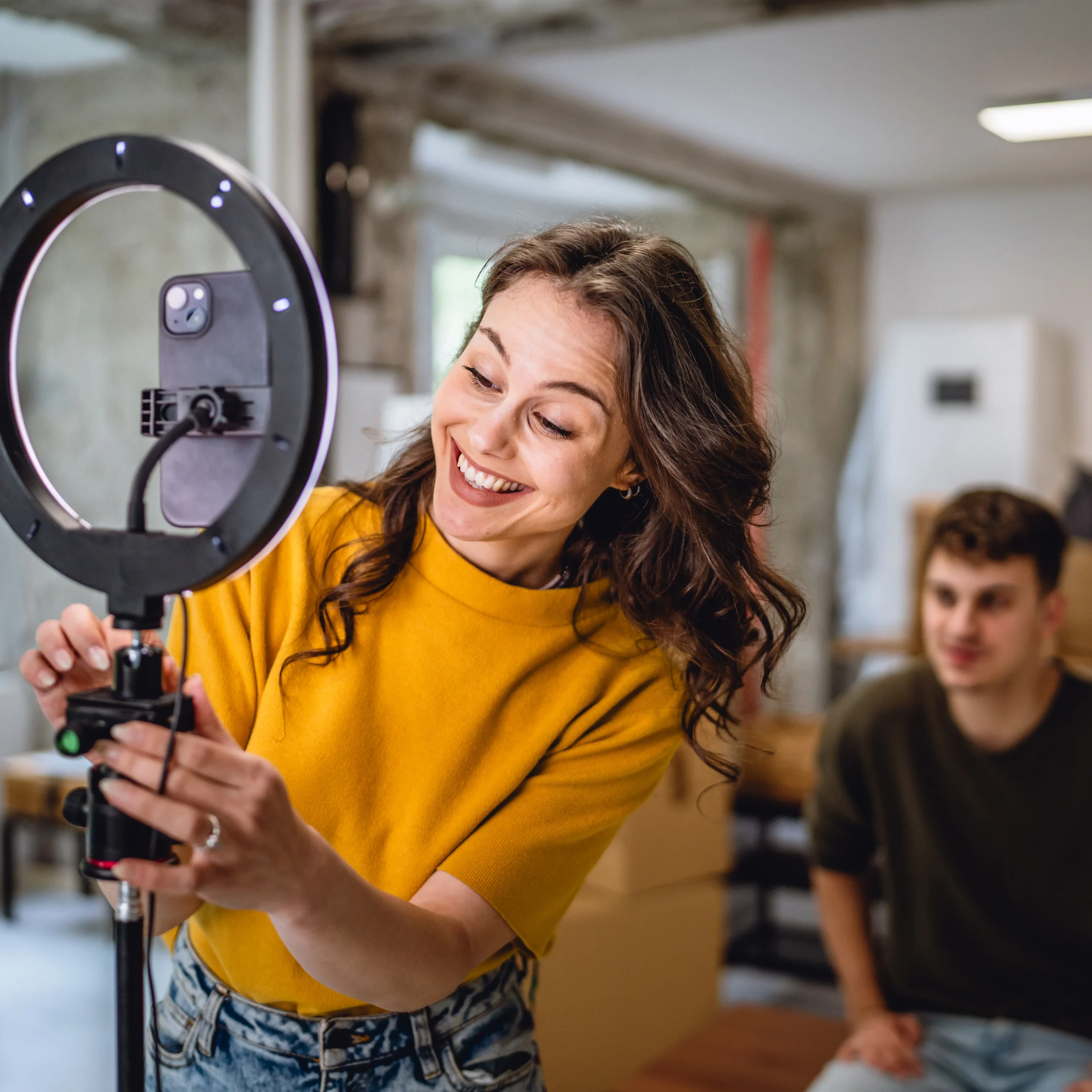 Zwei Menschen bereiten ein Ringlicht für einen Videodreh vor. Symbol für Bildproduktion und Markeninszenierung im HR Marketing.